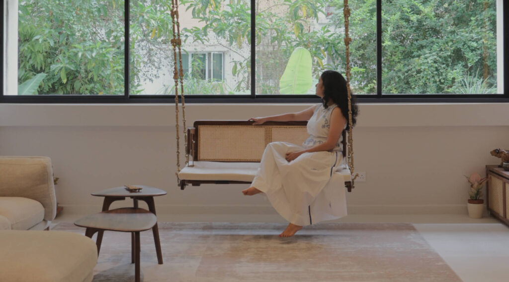Hanging swing in a biophilic living room overlooking treetops